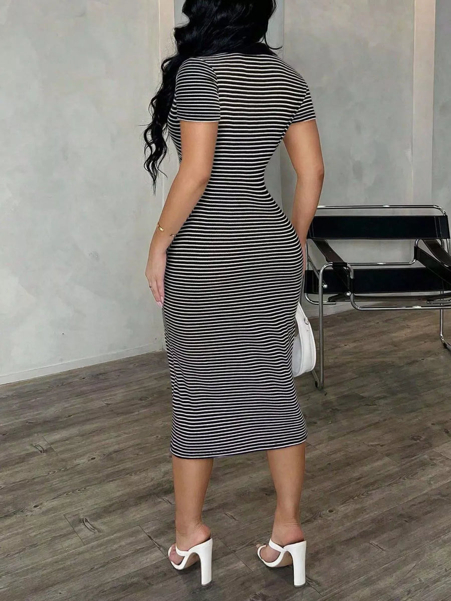 Woman wearing a black and white striped dress in an indoor setting.
