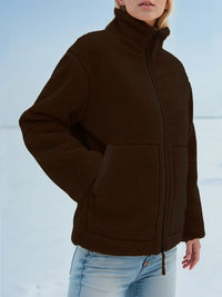 Person wearing a brown jacket with a snowy background