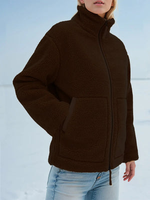 Person wearing a brown jacket with a snowy background