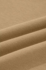A close-up of draped tan fabric with a fine knit texture, showing soft folds and shadows.