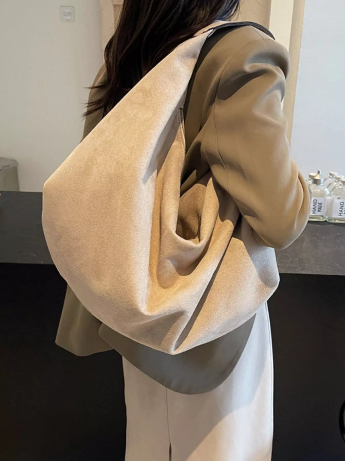 Person wearing a beige oversized sweater in an indoor setting