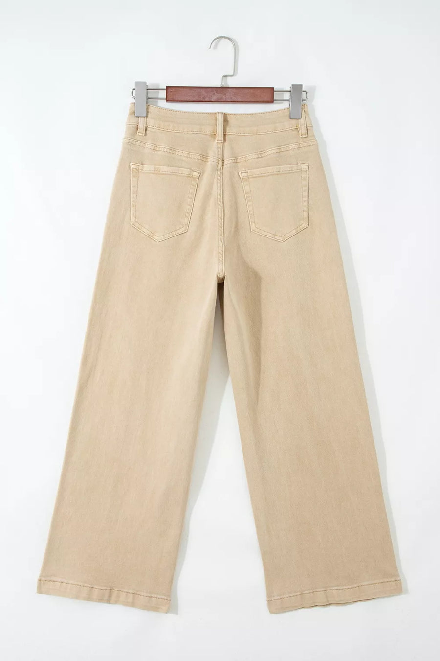 Beige pants on a hanger against a white background
