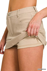 Beige shorts worn by a person on a white background
