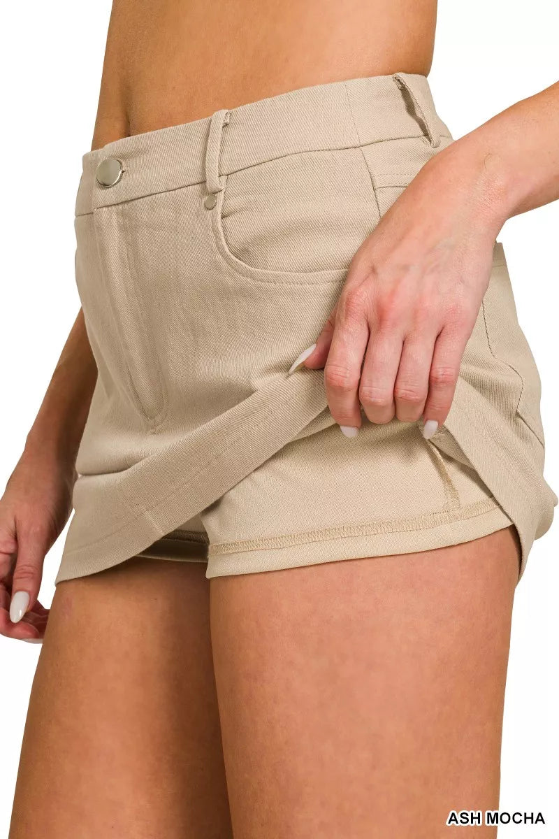 Beige shorts worn by a person on a white background