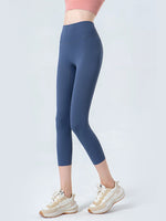 Person wearing blue leggings and white sneakers on a light gray background