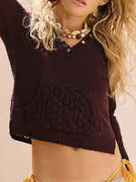 Woman wearing a dark brown knitted top with a textured pattern on a beige background