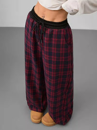 Plaid pajama pants worn by a person on a gray background