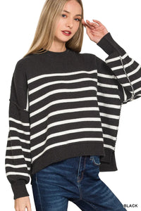 Woman wearing a black and white striped sweater with a plain background