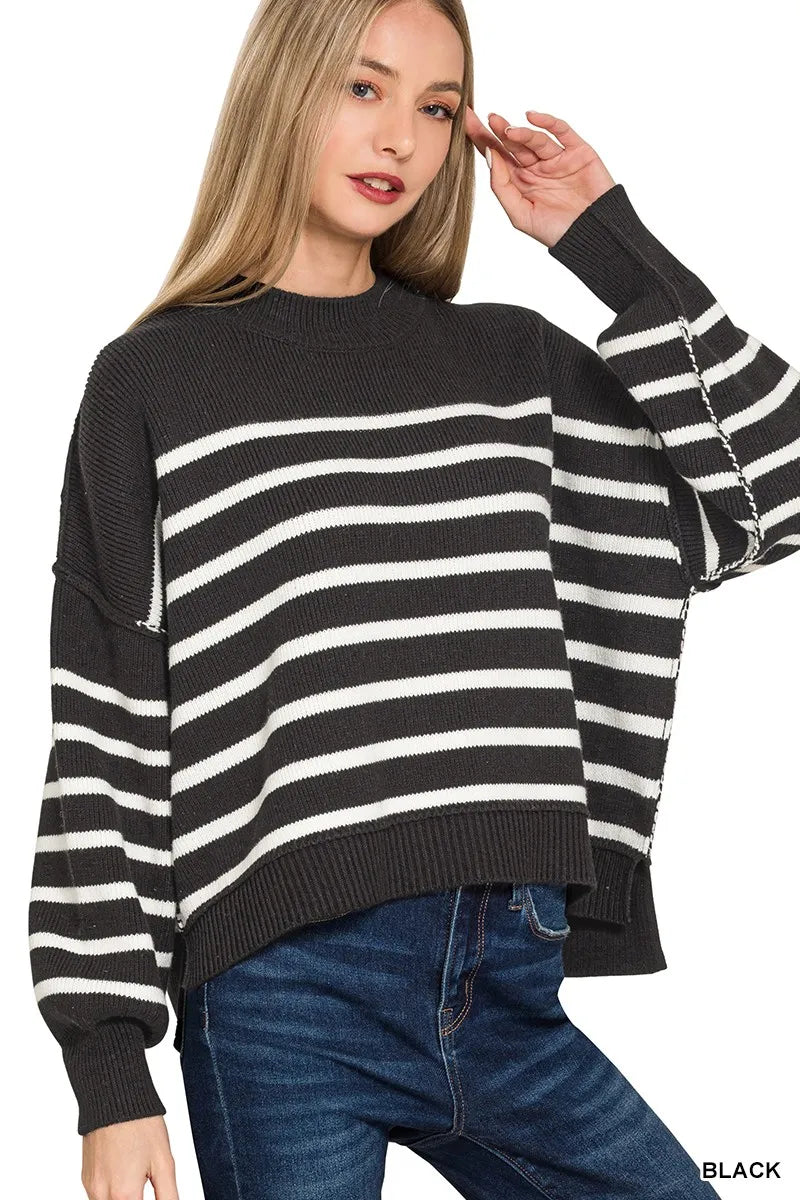 Woman wearing a black and white striped sweater with a plain background