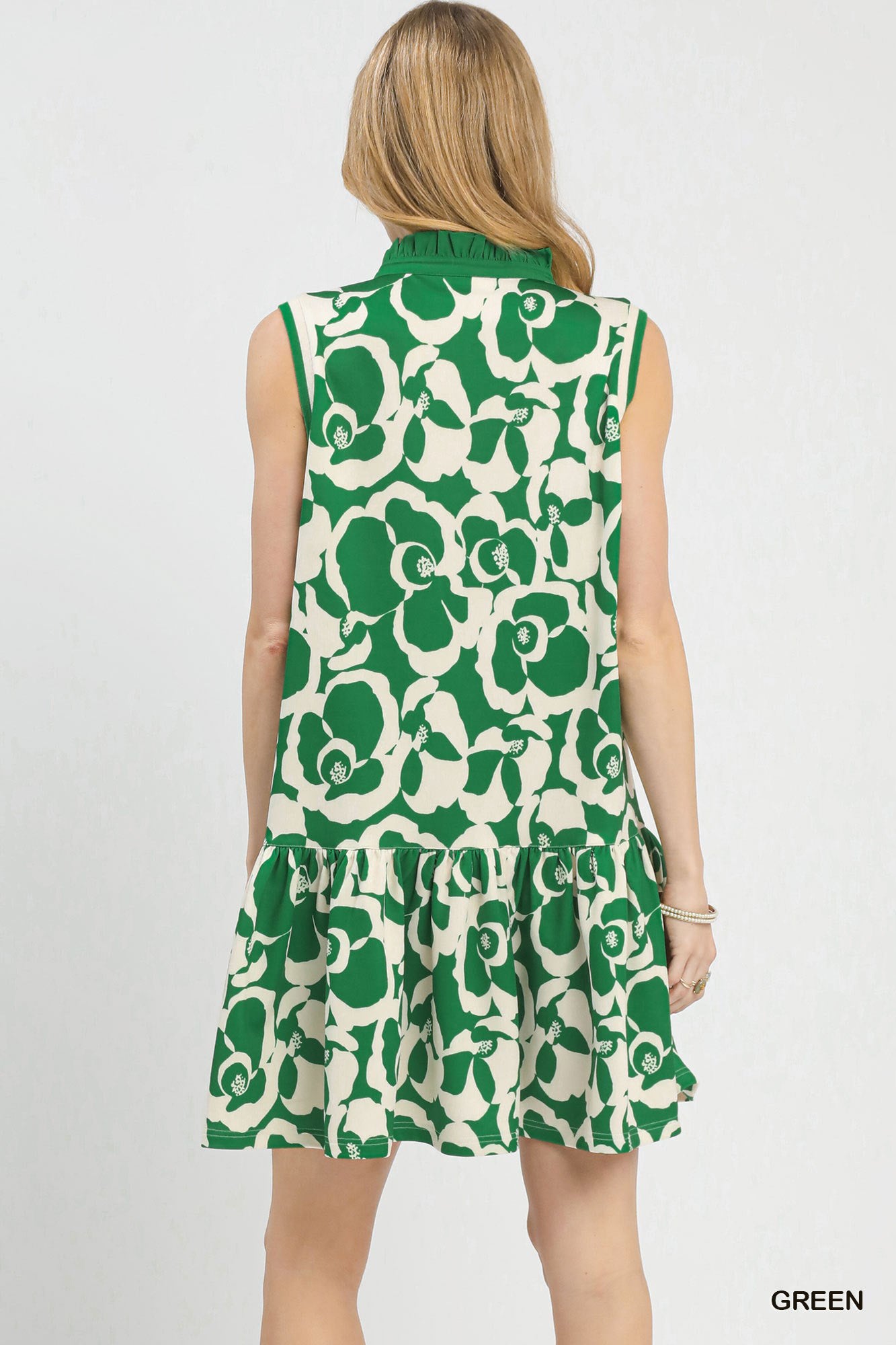 Green and white floral sleeveless dress on a model against a plain background