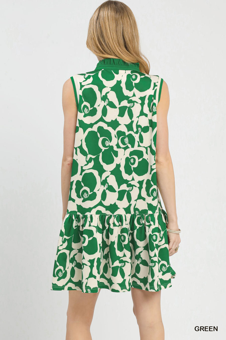 Green and white floral sleeveless dress on a model against a plain background