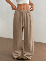Person wearing beige wide-leg pants against a plain background
