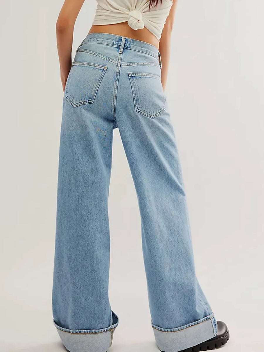 Light blue jeans worn by a person on a plain background