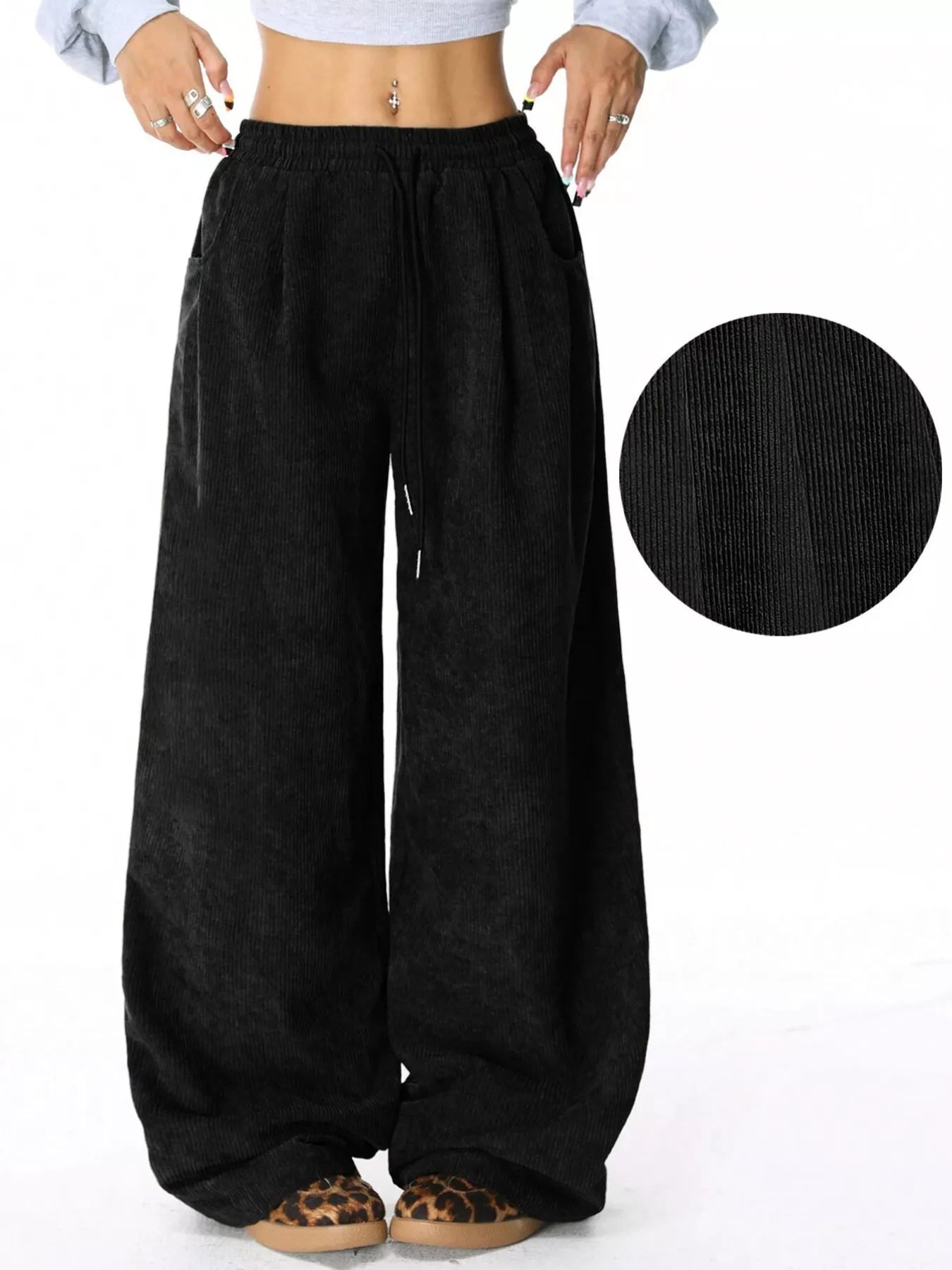 Black wide-leg pants with a close-up of the fabric texture on a white background