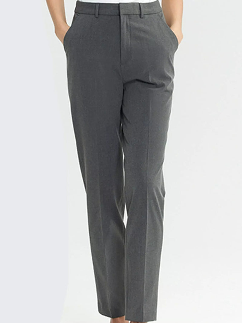 A person wearing dark gray straight-leg dress pants with a flat front and side pockets, shown from the waist down against a light gray studio background.
