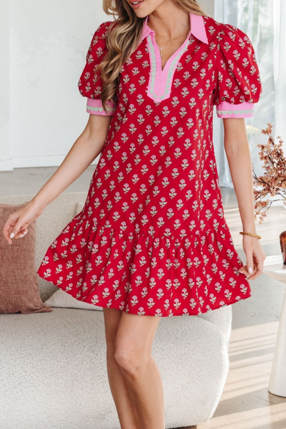 Woman wearing a red floral dress in a living room setting