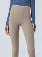 Beige leggings worn with a blue long-sleeve top on a light gray background