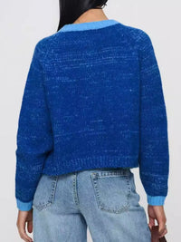 Blue textured sweater worn by a person on a plain background