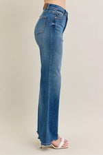 Blue jeans worn by a person on a beige background