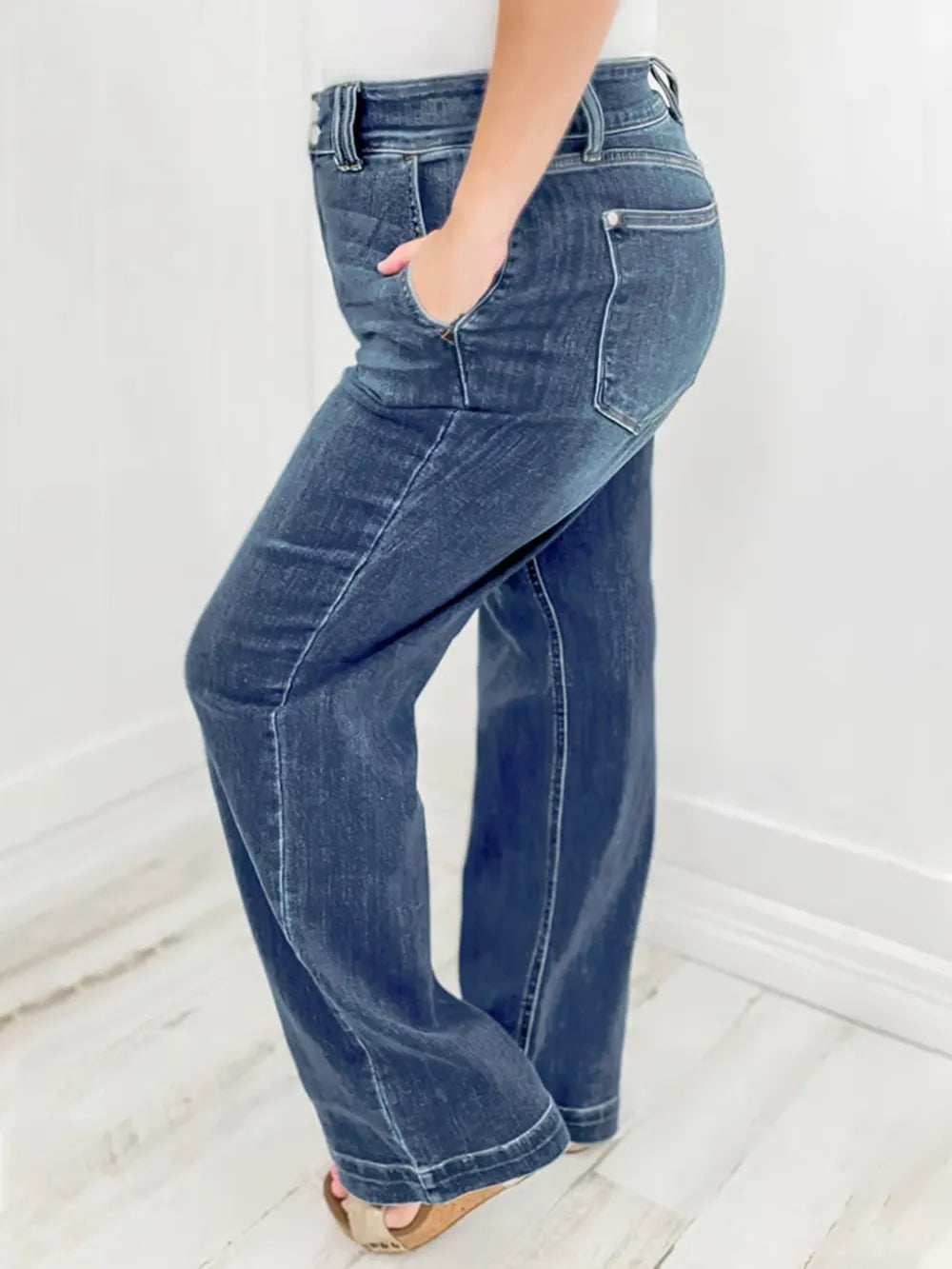 Blue jeans worn by a person on a white background