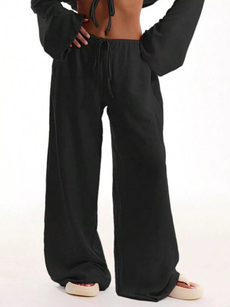 Black wide-leg pants worn by a person on a white background