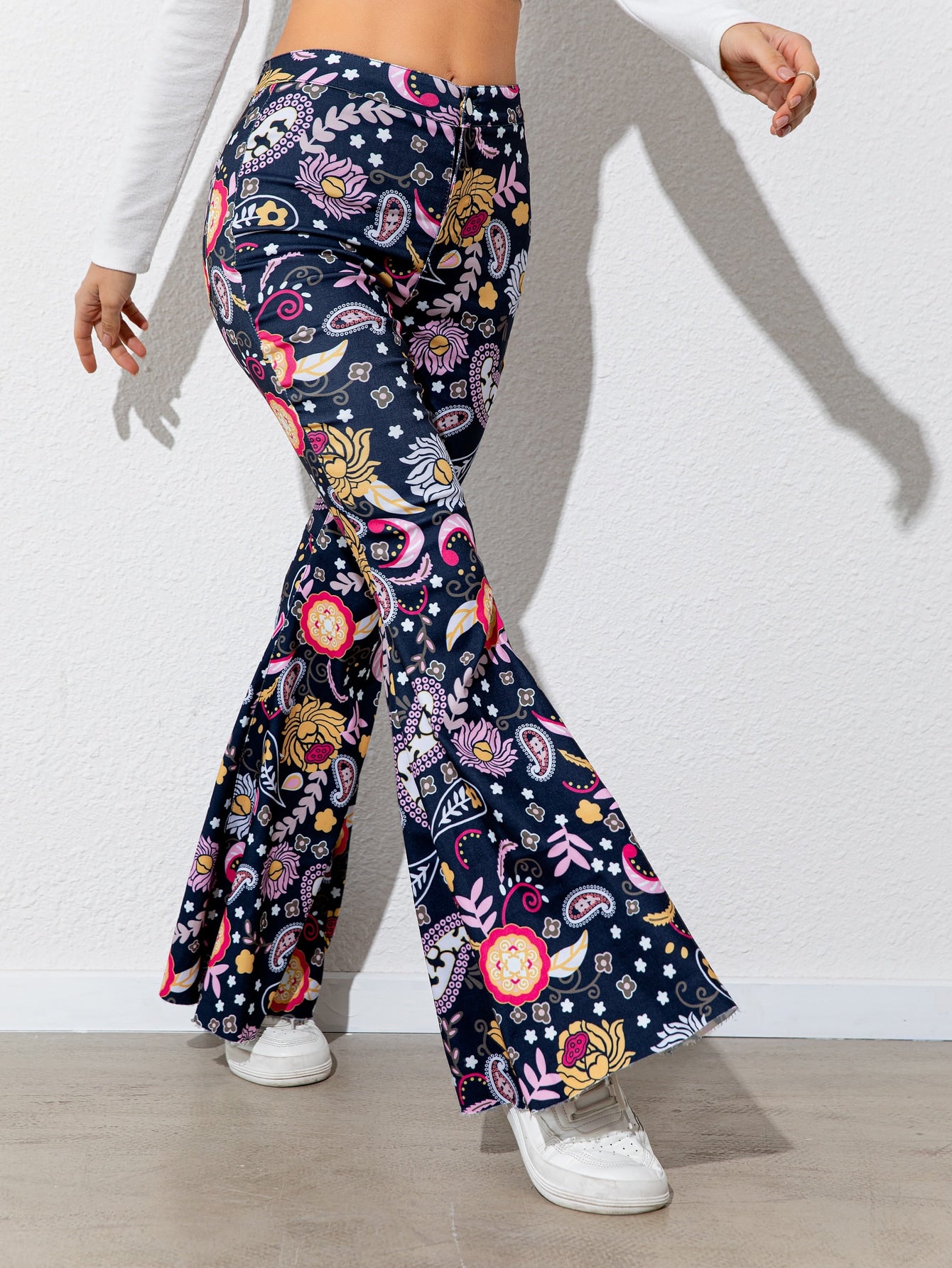 Navy blue pants with colorful floral pattern worn by a person on a white background