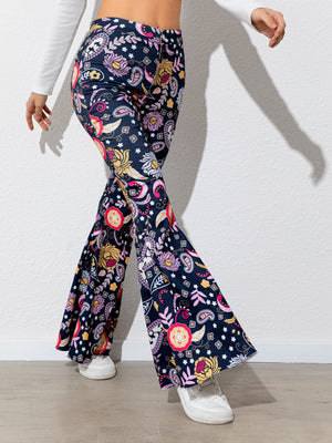 Navy blue pants with colorful floral pattern worn by a person on a white background