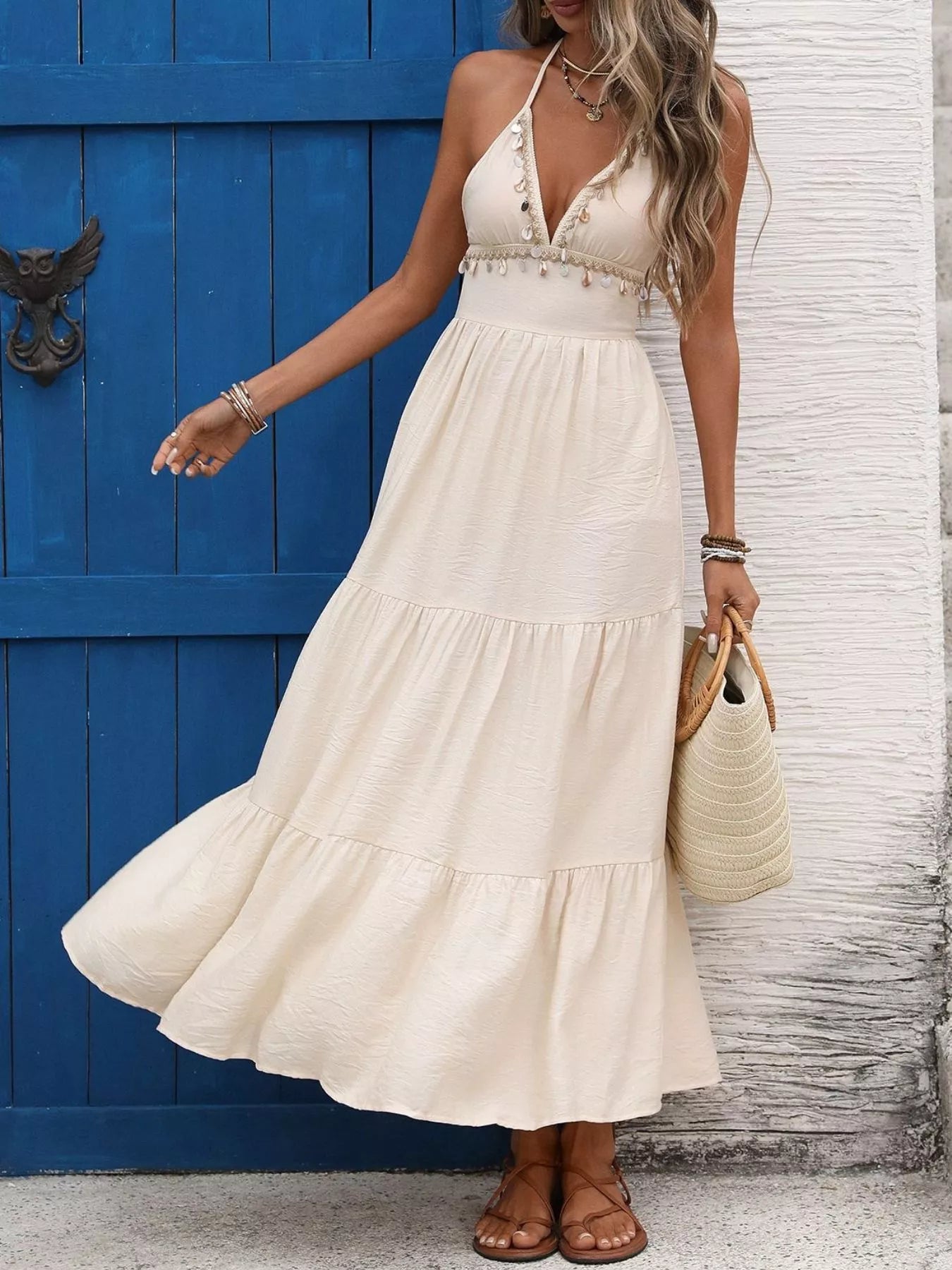 Woman wearing a white dress standing in front of a blue door.