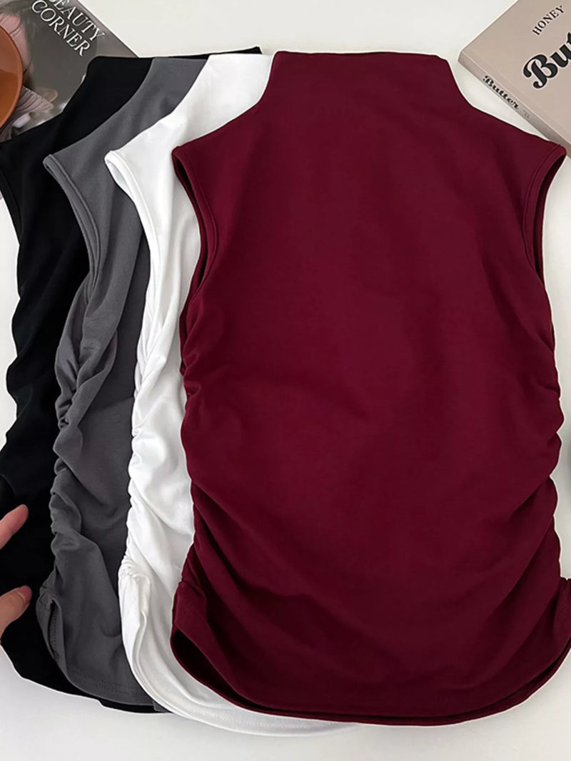 Three sleeveless shirts in black, white, and burgundy on a white background