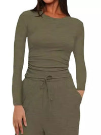 Person wearing a green long-sleeve top and pants on a white background