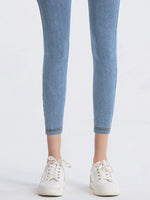 Light blue jeans worn by a person on a white background