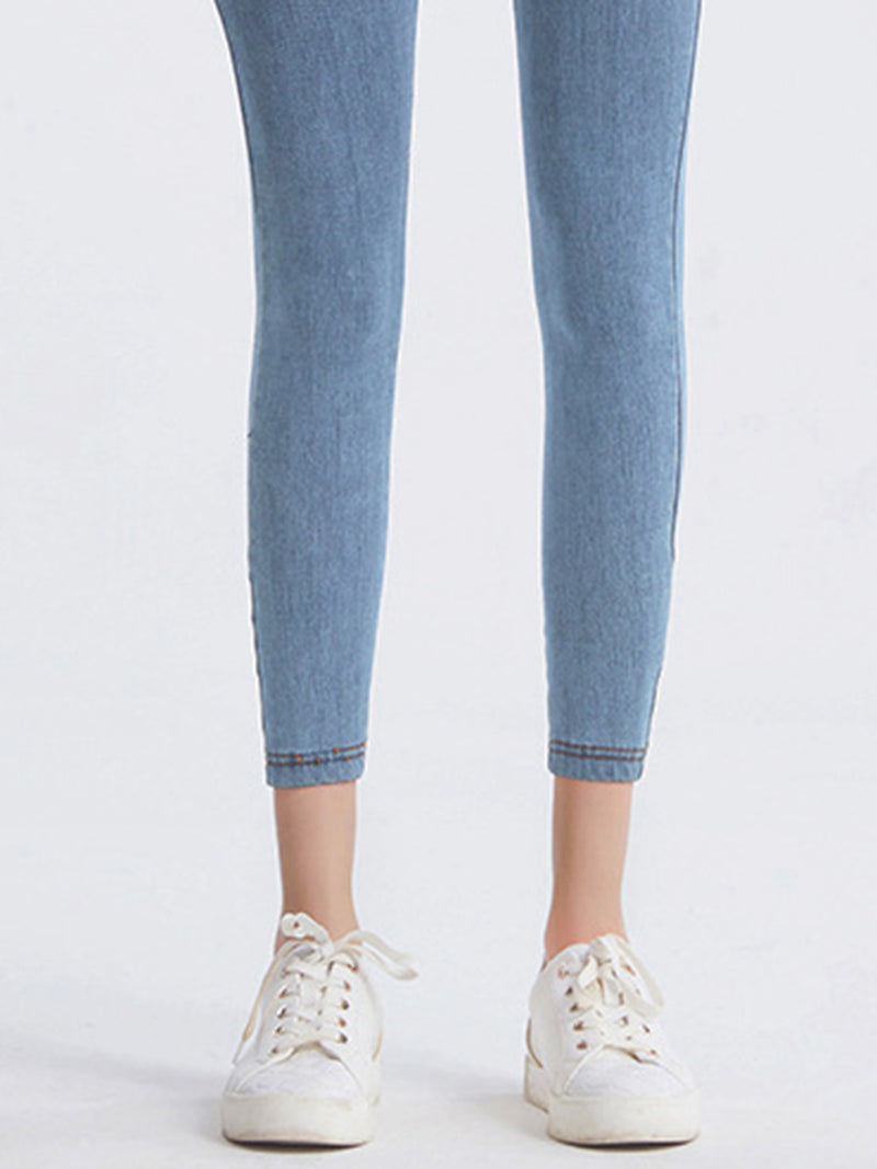Light blue jeans worn by a person on a white background