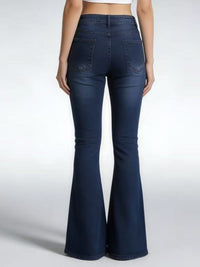 Navy blue flared jeans worn by a person on a white background