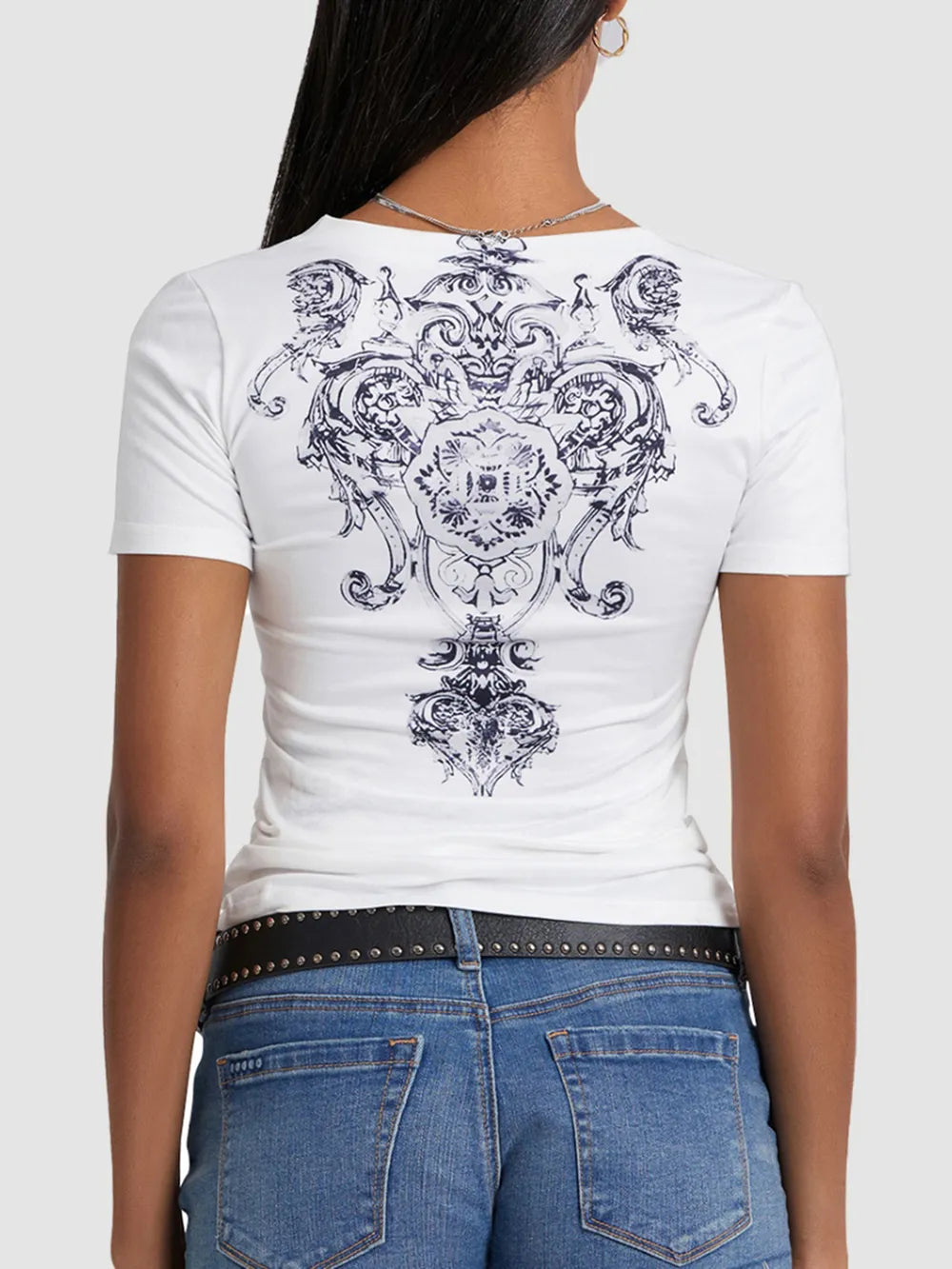 White t-shirt with black intricate design worn by a person, on a white background
