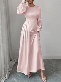 Pink long-sleeve dress worn by a model against a neutral background