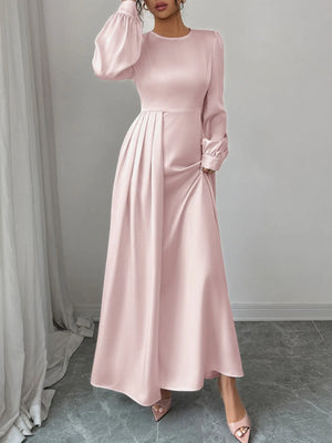 Pink long-sleeve dress worn by a model against a neutral background