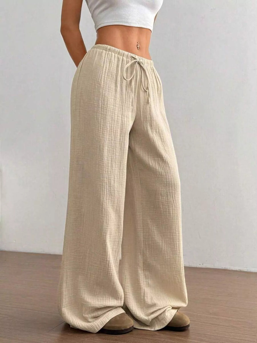 Beige wide-leg pants worn by a person on a plain background