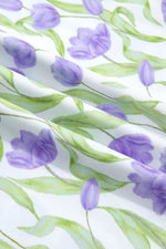 Pattern of purple tulips and green leaves on a white background