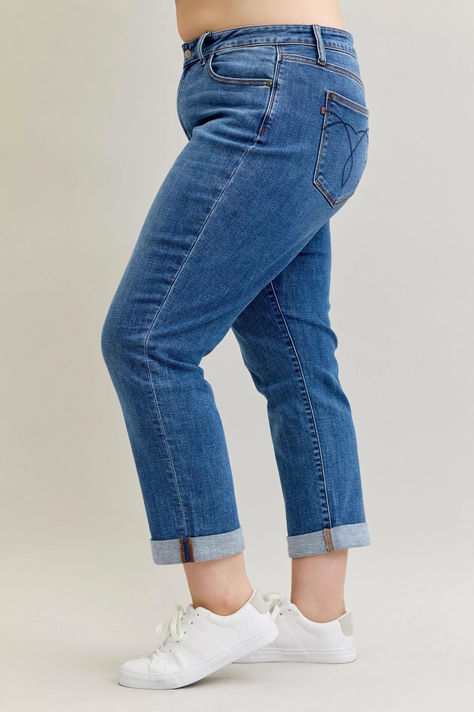 Blue jeans worn by a person on a plain background