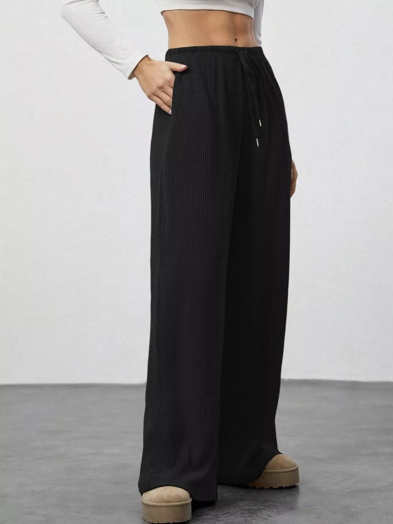 Black wide-leg pants worn by a person on a plain background