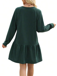 Green dress with long sleeves and a skirt on a white background