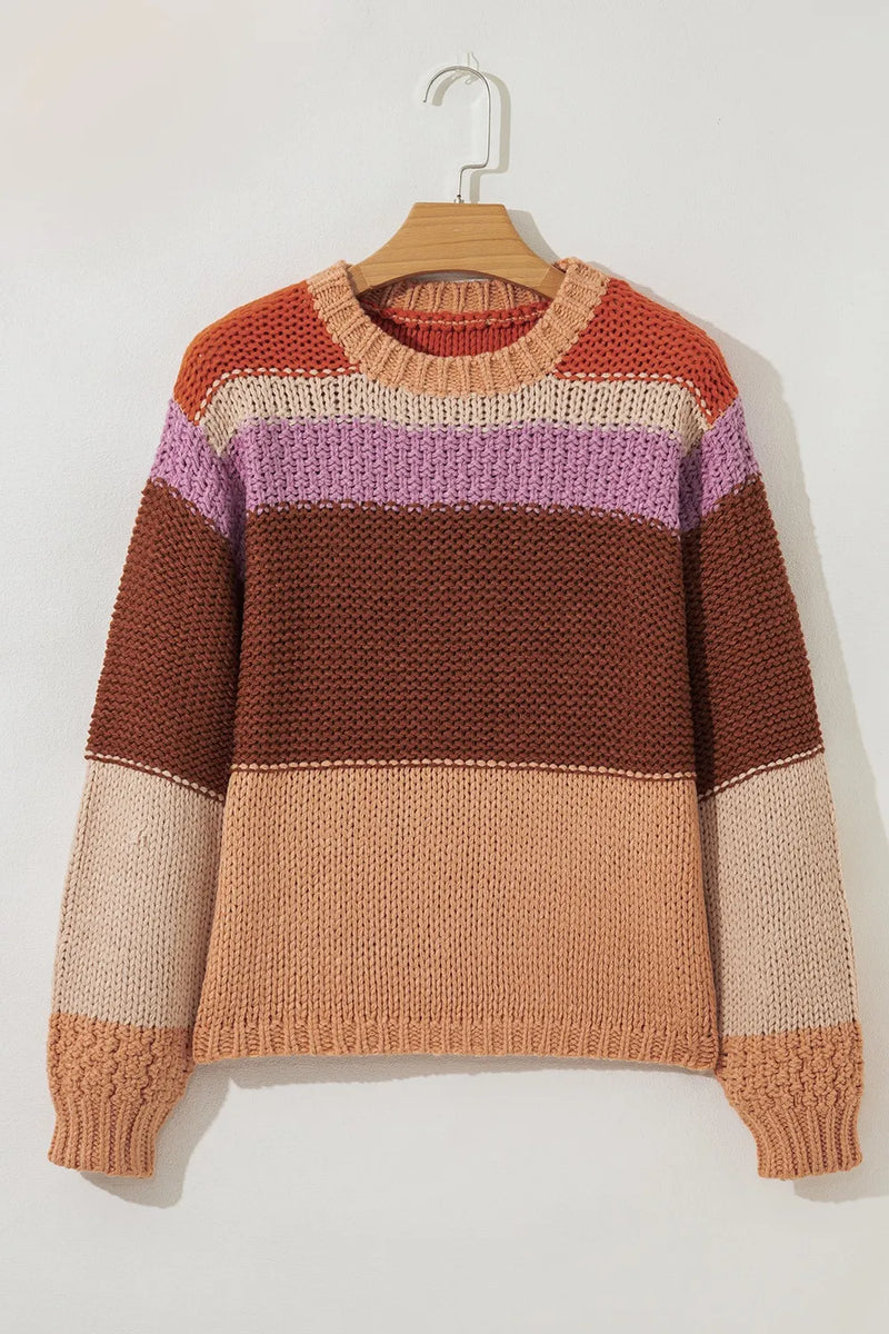 Color-blocked sweater on a hanger against a white background