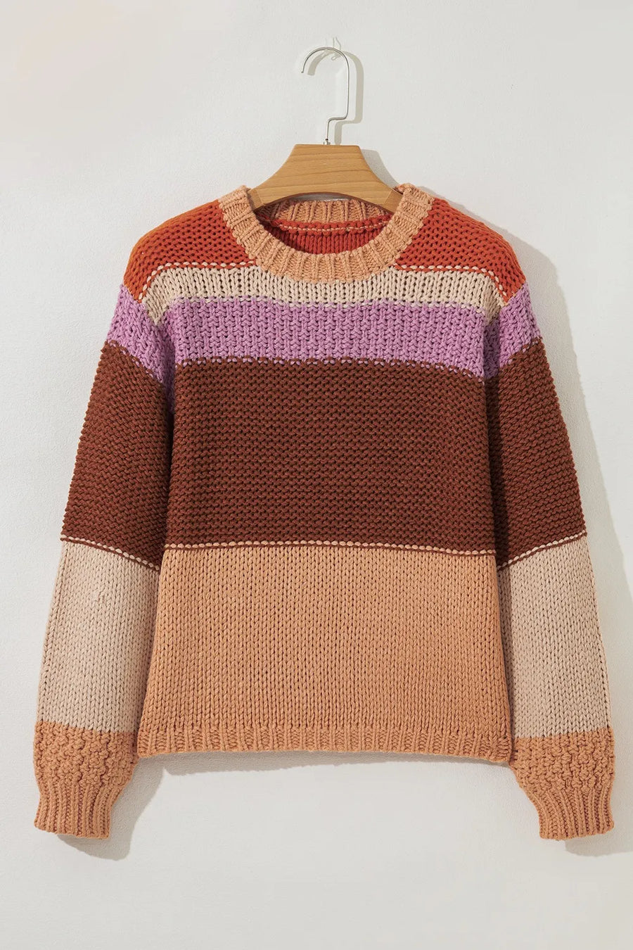 Color-blocked sweater on a hanger against a white background