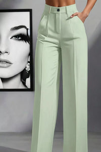 Light green pants worn by a person with a framed black and white portrait in the background.