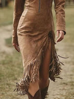 Brown suede dress with fringe details worn by a person outdoors.