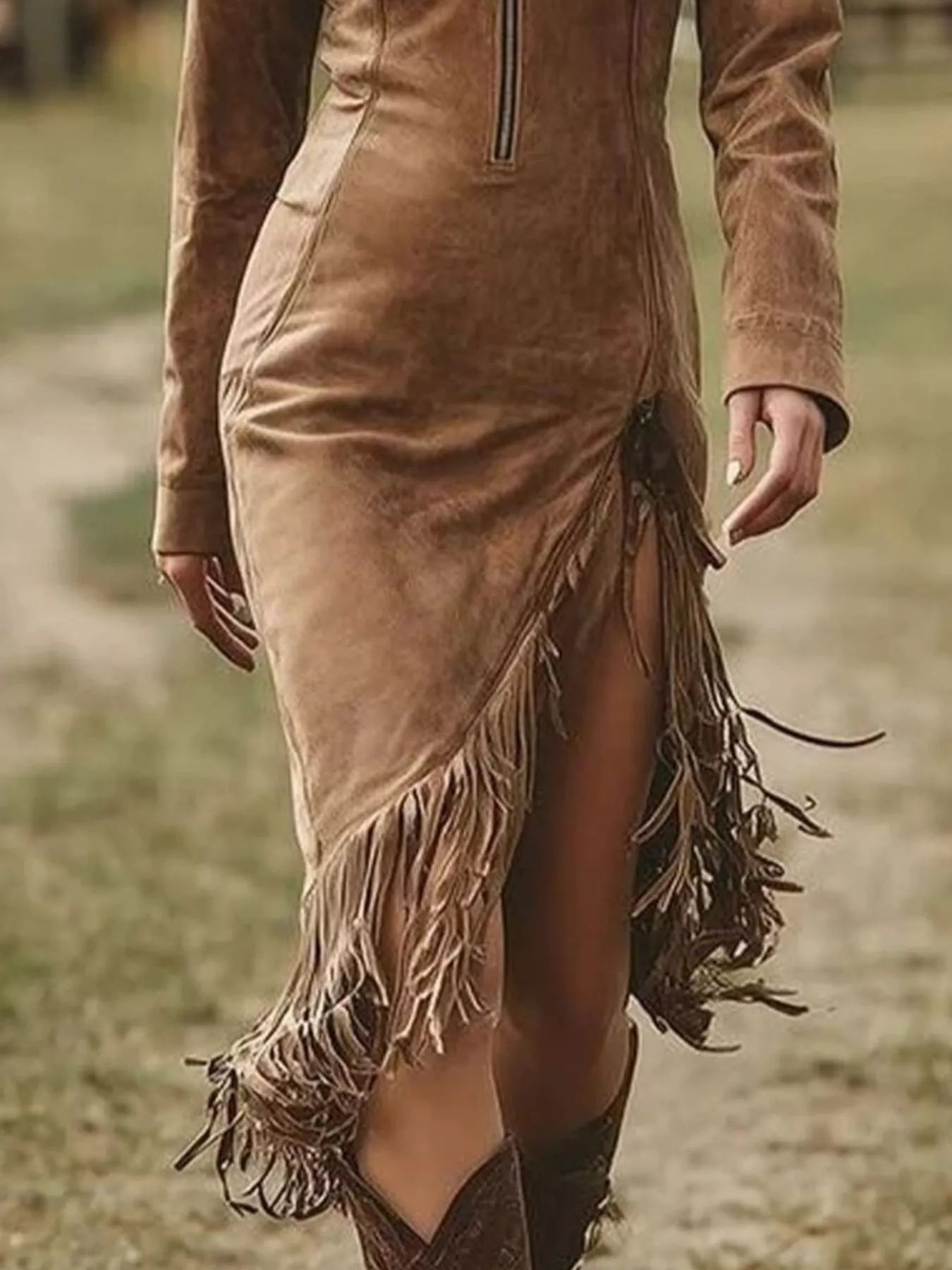 Brown suede dress with fringe details worn by a person outdoors.