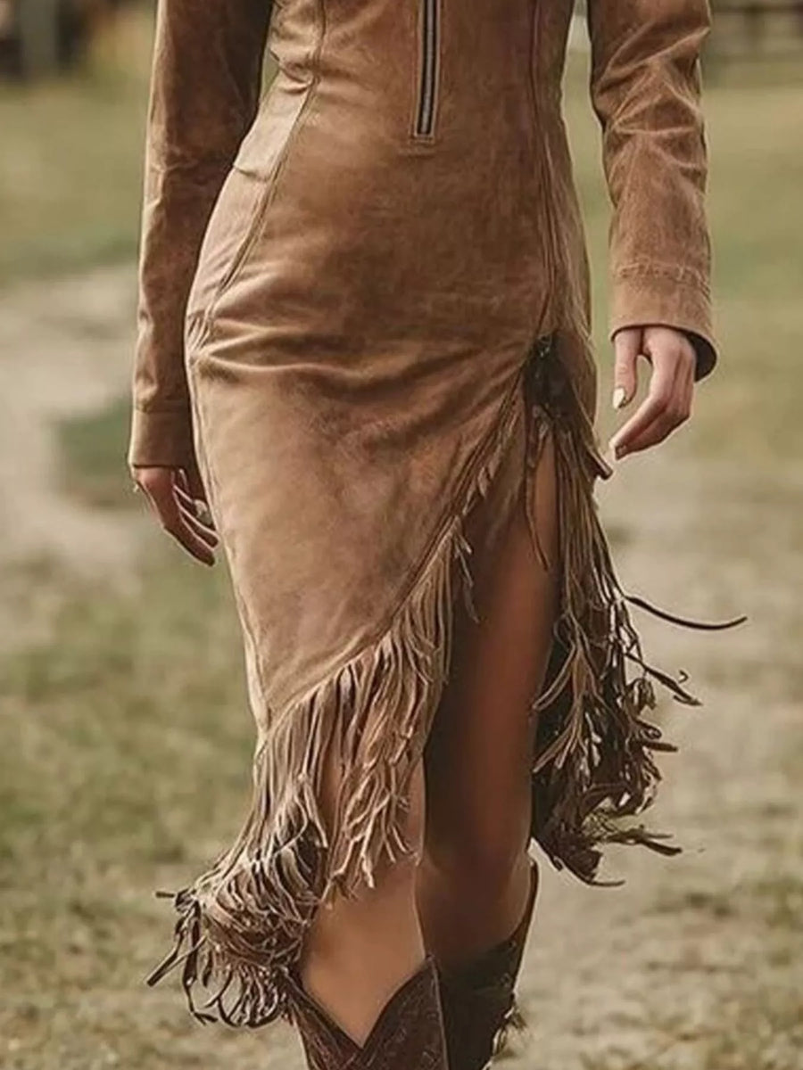 Brown suede dress with fringe details worn by a person outdoors.