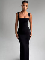 Woman wearing a black evening gown against a gray background