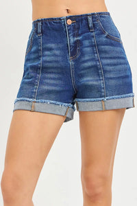 Blue denim shorts with rolled-up hem on a white background