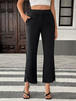 Person wearing black pants with a white top on a street.